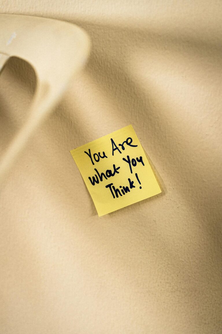 Yellow sticky note with motivational message on beige surface.