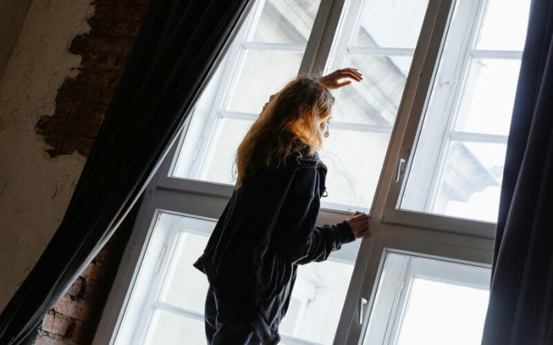 woman looking window waiting for perfect moment success